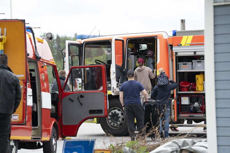 Ryhmä ihmisiä seisoo paloauton ympärillä.