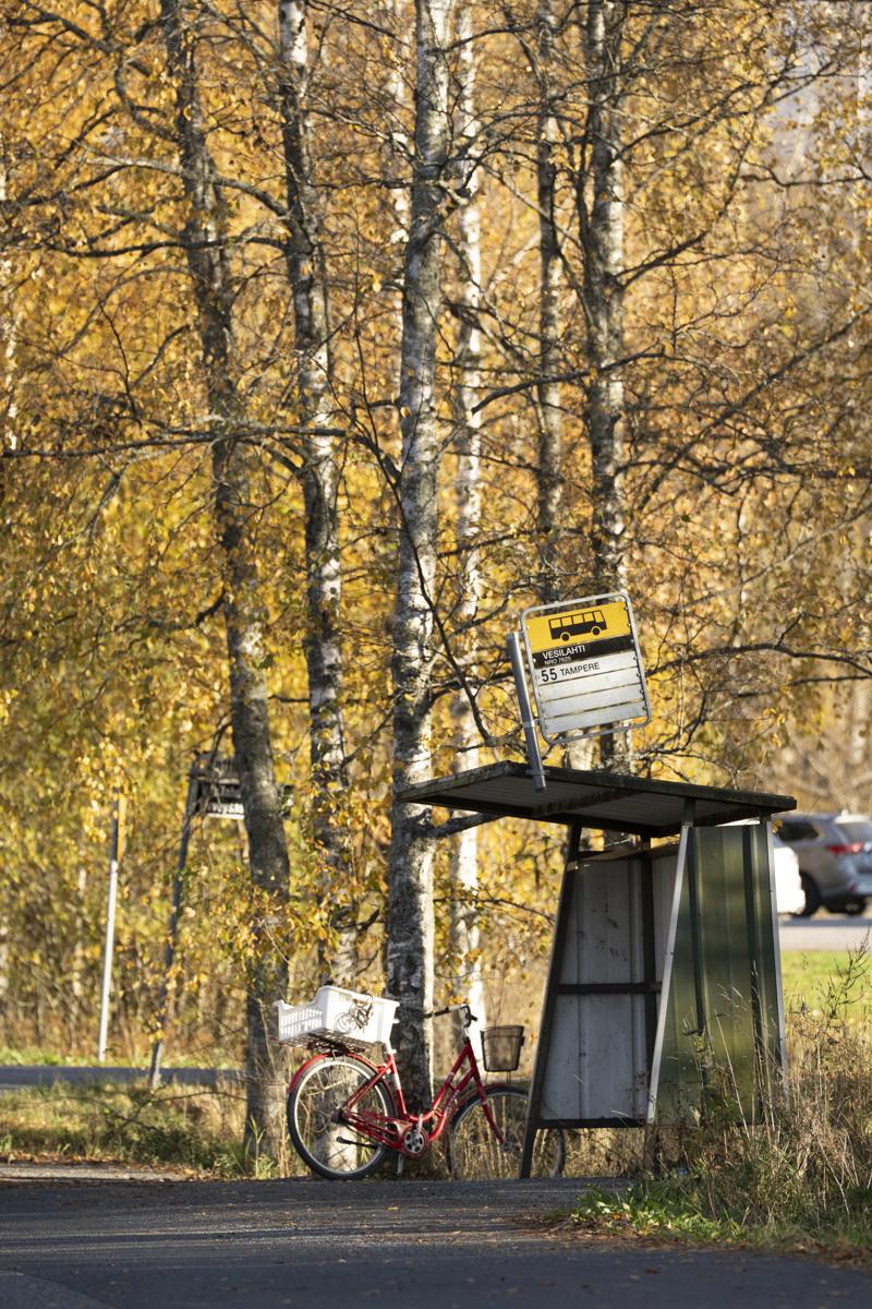 Polkupyörä on pysäköity tienvarteen bussipysäkin viereen.