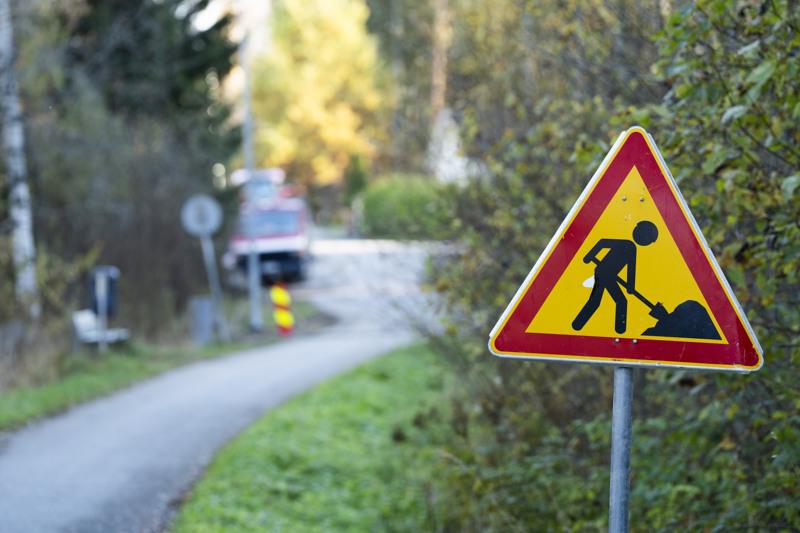 Keltainen ja punainen kyltti, joka on tienvarressa.